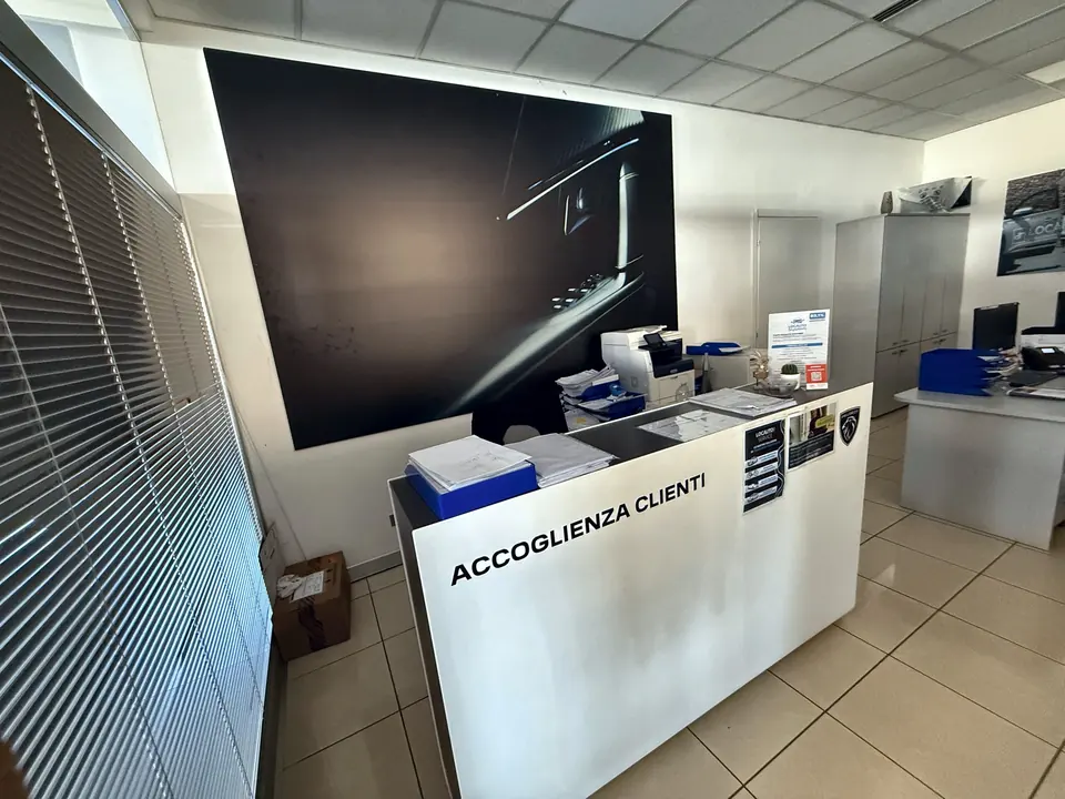 Banco accoglienza clienti con grafica a parete in uno showroom