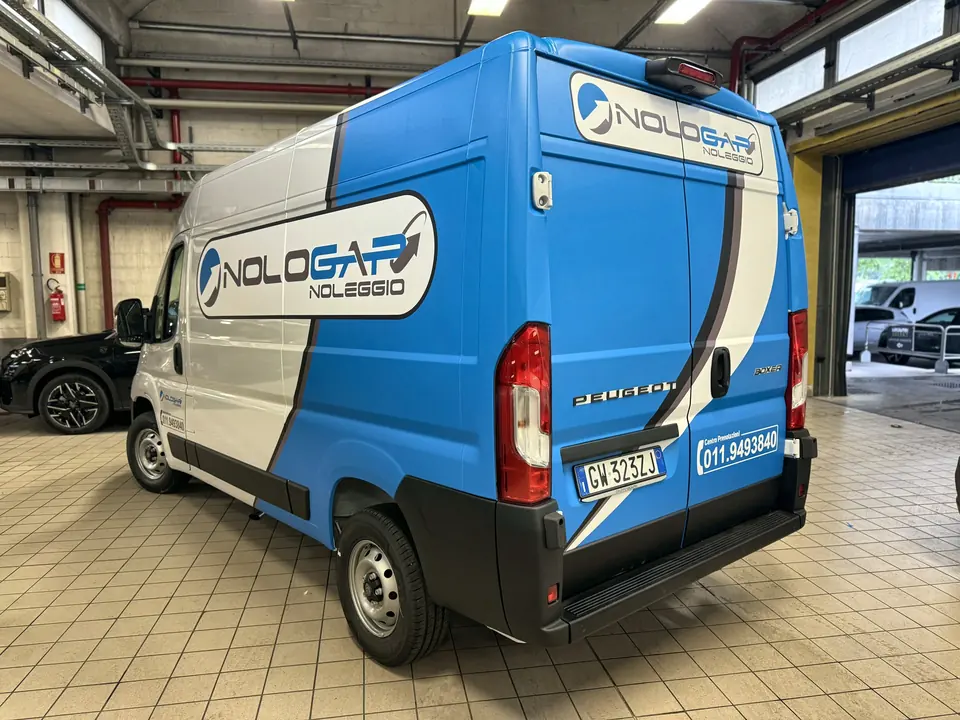 Furgone con wrapping blu e bianco, vista posteriore di tre quarti