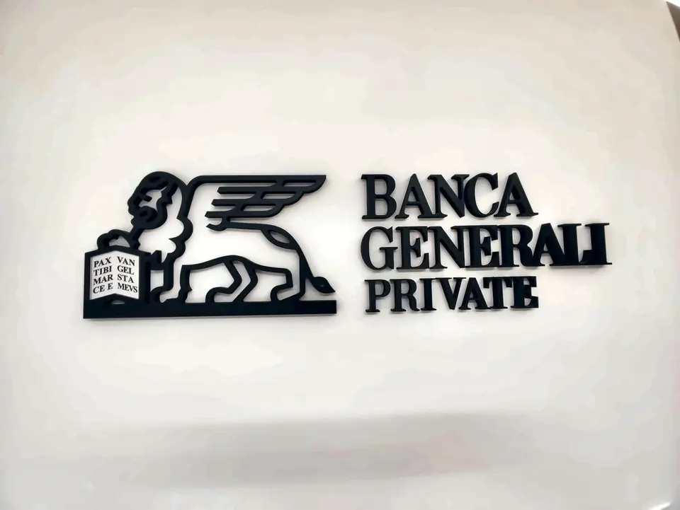 Logo in rilievo nero montato sulla parete chiara di una reception