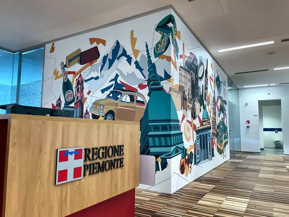 Grafica murale illustrata con la Mole Antonelliana e simboli del Piemonte negli uffici di Regione Piemonte