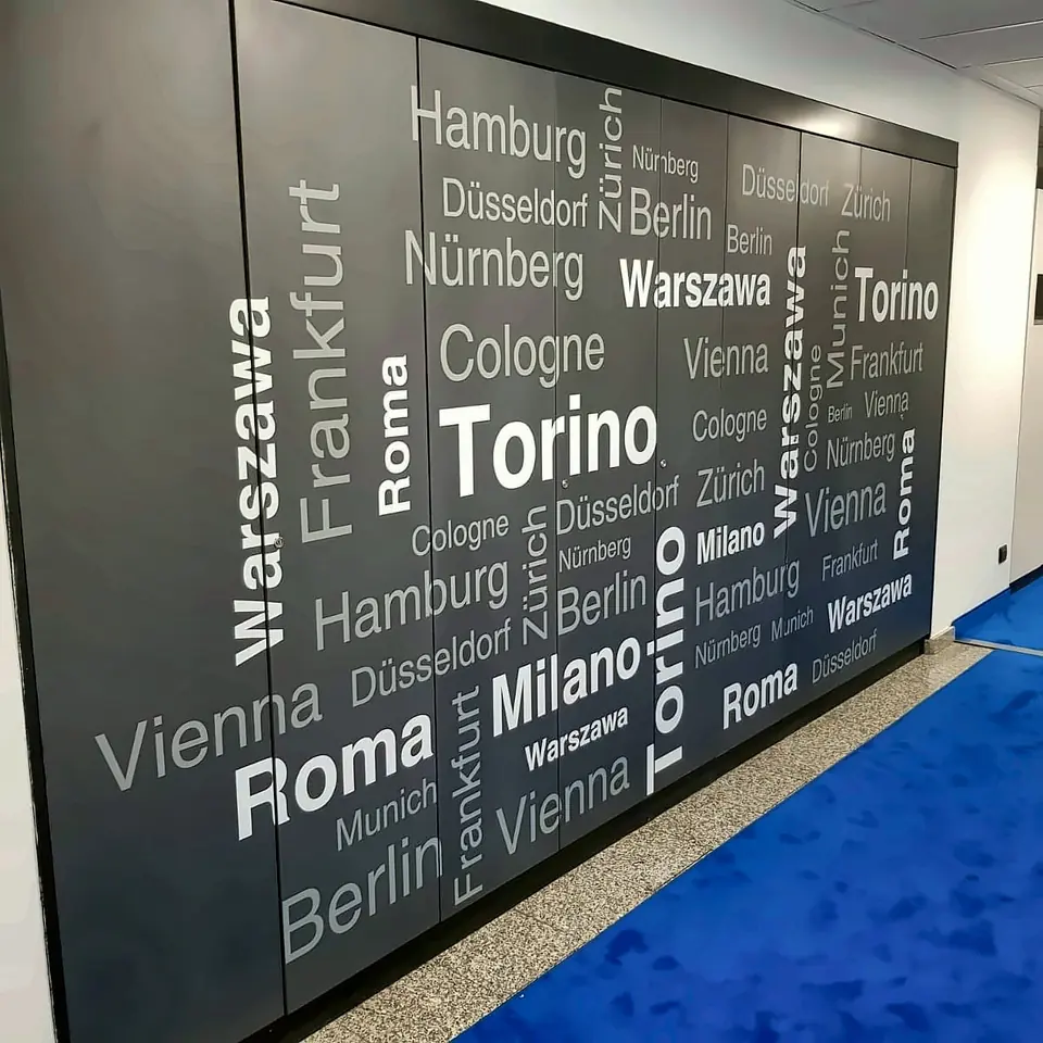 Parete con grafica tipografica di nomi di città europee