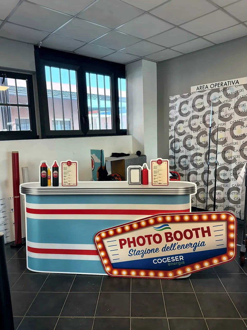 Photo booth allestito per un evento, con banco decorato e pannelli grafici