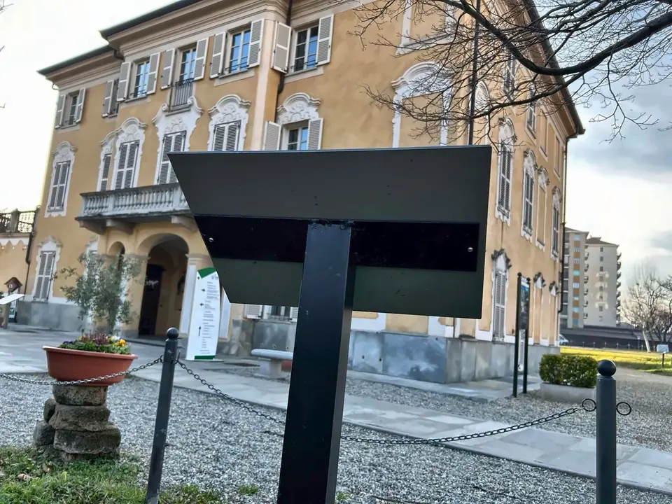 Targa su supporto nel giardino di un edificio storico