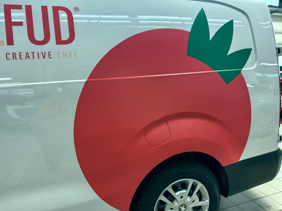 Dettaglio della fiancata di un furgone con un grande pomodoro stampato